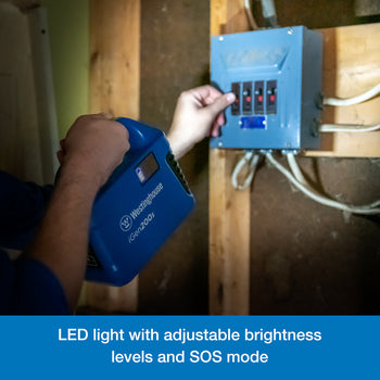 Westinghouse | iGen200s Portable Power Station flashlight feature being used to illuminate a box of circuit breakers. A blue banner along the bottom reads,