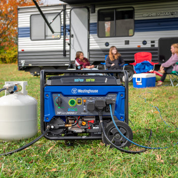 Westinghouse | WGen3600DF portable generator connected to a propane tank sitting in the grass with people camping in the background.