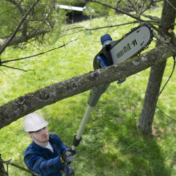 Man using pole saw on a high up tree branch