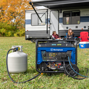 Westinghouse | WGen3600DFc portable generator connected to a propane tank sitting in the grass with people camping in the background.